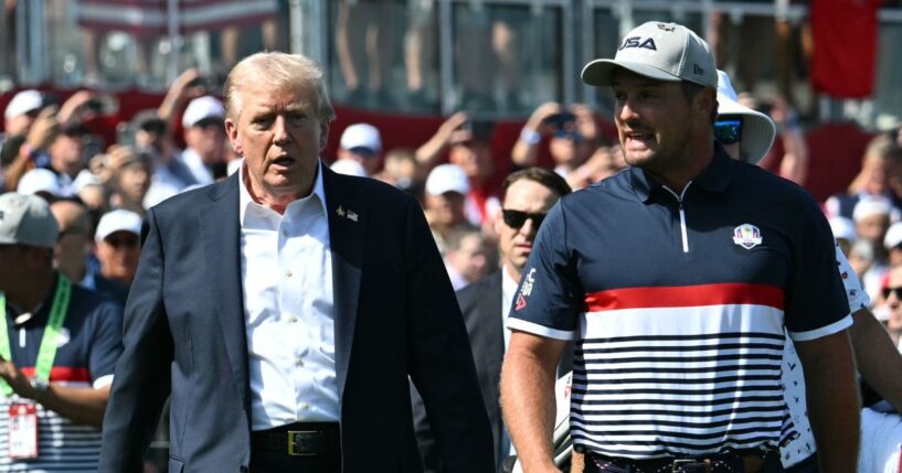 President Donald Trump walks with pro golfer Bryson DeChambeau as he attends the 2025 Ryder Cup at Black Course at Bethpage State Park Golf Course on Sept. 26, 2025, in Farmingdale, New York.