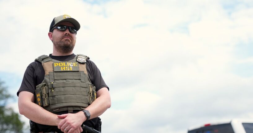 A Homeland Security Investigations officer, the investigative arm of the U.S. Department of Homeland Security, stands by as the U.S. Park Police inspect a vendor's truck after detaining a person on the National Mall on Aug. 13, 2025, in Washington, D.C.
