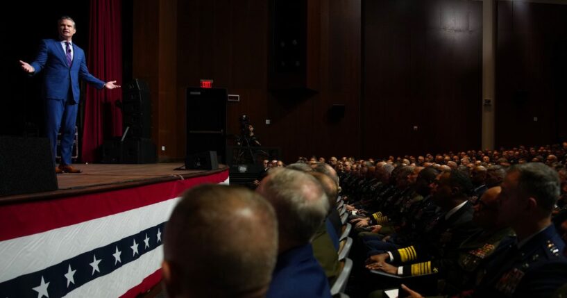 Secretary of War Pete Hegseth, left, speaks to senior military leaders at Marine Corps Base Quantico in Quantico, Virginia, on Tuesday.