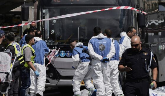 Israeli police and rescue teams inspect the scene of a shooting attack carried out by two Palestinian gunmen, in which several people were killed and others injured at a bus stop in Jerusalem on Monday.