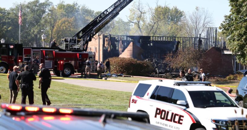 Fire and law enforcement officers stand outside the Church of Jesus Christ of Latter-day Saints in Grand Blanc Township, Michigan, following a shooting and fire on Sunday.