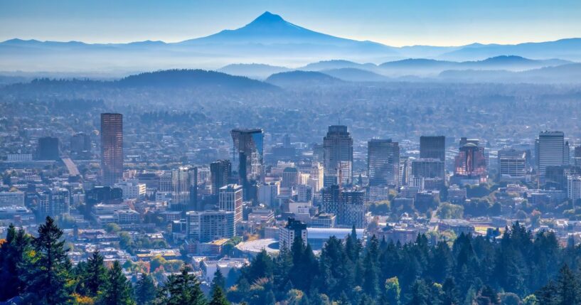 The skyline of Portland, Oregon, is pictured with Mt. Hood in the background.