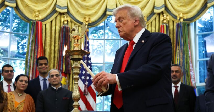 President Donald Trump lights a diya candle during an event celebrating Diwali in the Oval Office of the White House in Washington, D.C., on Tuesday.