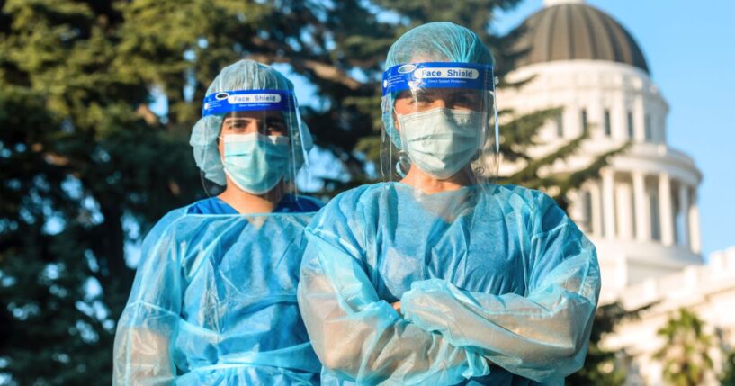 A stock photo shows masked health care workers in front of the state capitol building. Several California counties are mandating masks in health care settings from Nov.1 through March 31.