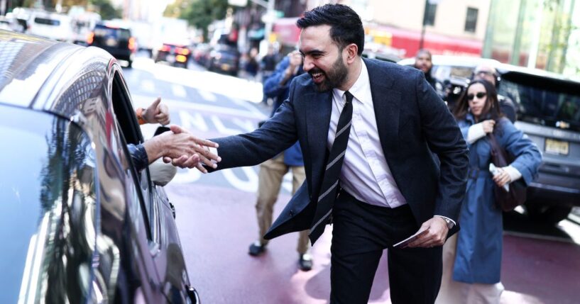 Democratic socialist candidate Zohran Mamdani greets people on the street Monday in the Manhattan borough of New York City during early voting for the upcoming mayoral election.