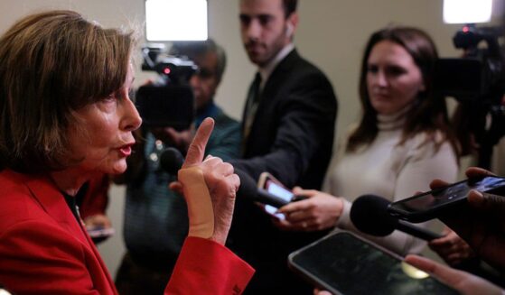 Rep. Nancy Pelosi, a Democrat from California, talks to reporters in the hallway outside of a House Democratic caucus meeting at the U.S. Capitol Visitors Center Wednesday in Washington, D.C.