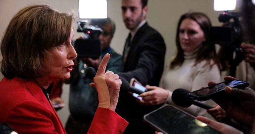 Rep. Nancy Pelosi, a Democrat from California, talks to reporters in the hallway outside of a House Democratic caucus meeting at the U.S. Capitol Visitors Center Wednesday in Washington, D.C.