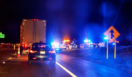 A stock photo shows a highway scene at night with emergency vehicles responding to an accident.