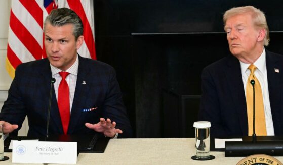 President Donald Trump listens to Defense Secretary Pete Hegseth during a law enforcement roundtable in the State Dining Room of the White House on Oct. 23, 2025, in Washington, D.C.