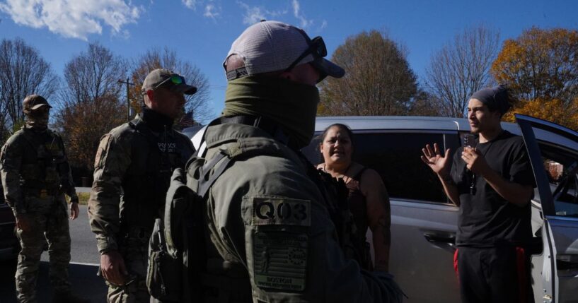 Department of Homeland Security Investigations officers question an individual after two people fled the scene while being stopped for selling flowers on the side of the road on Nov. 16, 2025, in Charlotte, North Carolina.