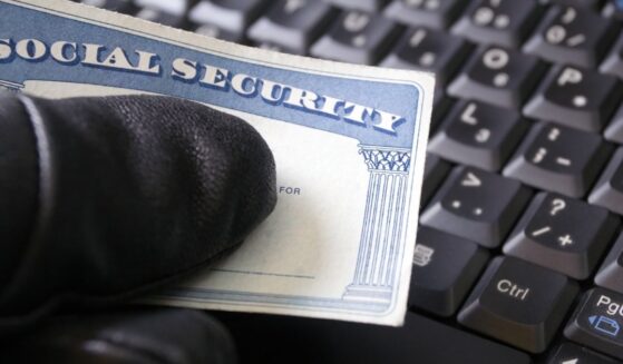 A man's hand holding a Social Security card.