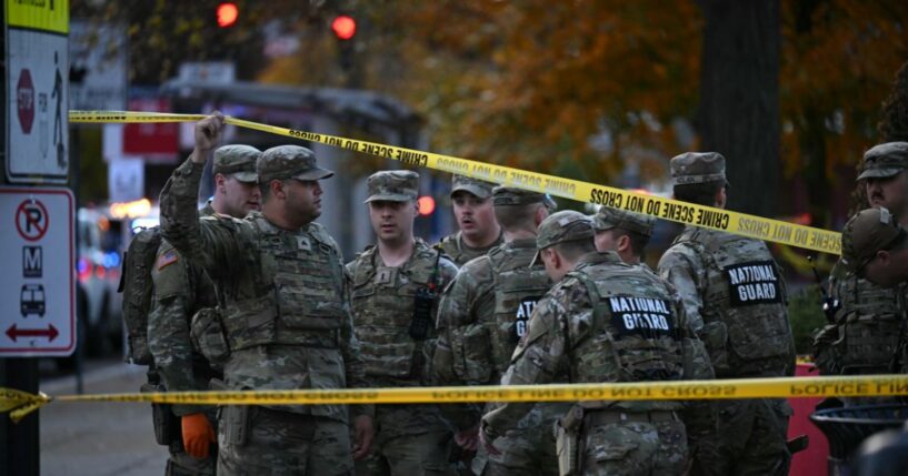 National Guard soldiers stand behind the crime scene tape at a corner in downtown Washington, D.C., on Nov. 26, 2025.