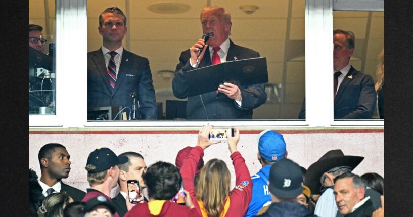 President Donald Trump, center, alongside Secretary of Defense Pete Hegseth, left, and Washington Commanders owner Josh Harris, right, reads the oath for people re-enlisting to the U.S. Army Sunday as he attends the NFL game between the Washington Commanders and the Detroit Lions in Landover, Maryland.