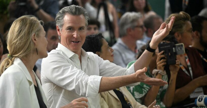 The Governor of California Gavin Newsom speaks with a woman during the COP30 UN Climate Change Conference, in Belem, Para State, Brazil, on November 11, 2025.