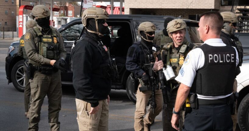 Border Patrol chief Greg Bovino speaks with a Chicago Police officer while searching for undocumented immigrants in a southwest side neighborhood on Nov. 6, 2025, in Chicago, Illinois.