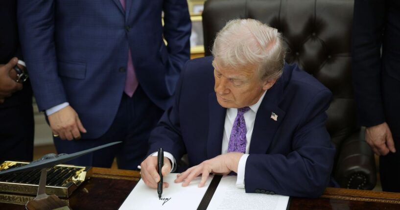 President Donald Trump signs an executive order in the Oval Office of the White House on Dec. 11, 2025, in Washington, D.C.
