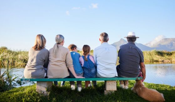 A family looking at a scenic view while sitting together in a nature reserve.