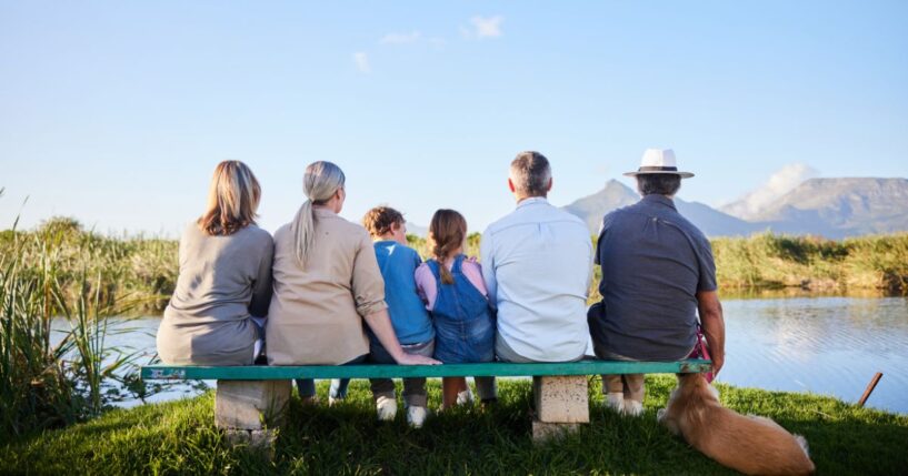 A family looking at a scenic view while sitting together in a nature reserve.