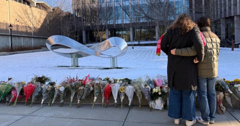 Senior Zoe Kass and her boyfriend leave flowers Dec. 16 at the engineering building at Brown University in Providence, Rhode Island. They fled the building Dec. 13 when a shooter opened fire during a finals study session.