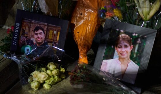 Framed photos of mass shooting victims Mukhammad Aziz Amurzokov and Ella Cook are seen Monday at a makeshift memorial near Brown University in Providence, Rhode Island.