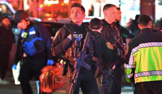 Law enforcement officials carrying weapons gather near Brown University in Providence, Rhode Island.