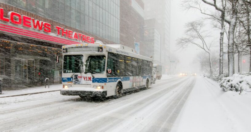 A bus drives through the winter on Broadway near 68th street in New York City during a snowfall on Feb. 9, 2017.