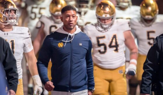 Head Coach Marcus Freeman of the Notre Dame Fighting Irish leads his team into the stadium Nov. 29 to start the second half of a college football game against the Stanford Cardinals in Palo Alto, California.