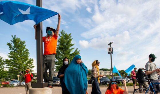 People hold up Somali flags during a protest calling for justice for Isak Aden on July 1, 2020 in Eagan, Minnesota. Isak Aden was killed on July 2, 2019 after a standoff with Eagan Police. No charges were brought against the officers involved in his death.