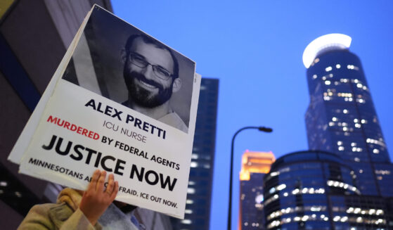 A person holds a sign of Alex Pretti during a protest outside the office of Sen. Amy Klobuchar on Jan. 26, 2026, in Minneapolis, Minnesota.