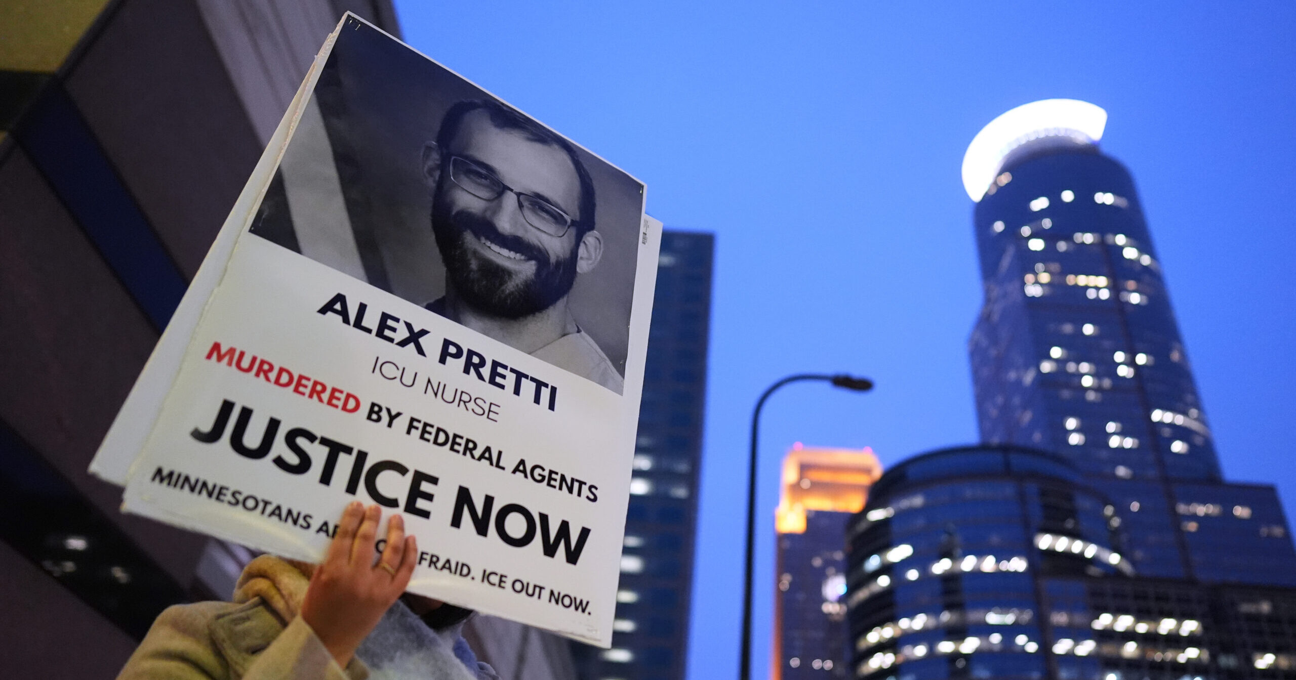 A person holds a sign of Alex Pretti during a protest outside the office of Sen. Amy Klobuchar on Jan. 26, 2026, in Minneapolis, Minnesota.