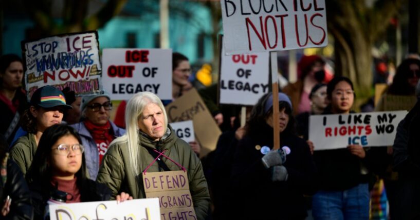 Anti-ICE activists display signs during a protest near Legacy Emanuel Hospital on Jan. 10, 2026, in Portland, Oregon.