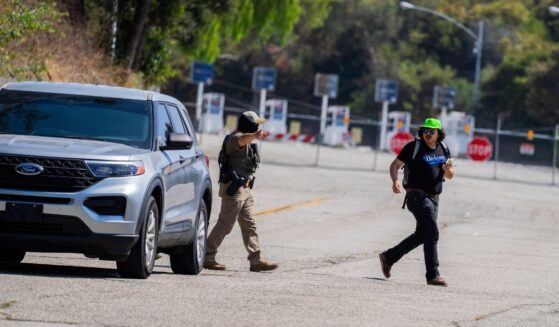 A federal agent gestures toward a National Lawyers Guild legal observer attempting to record license plates near Gate E of Dodger Stadium during a brief confrontation on June 19, 2025, in Los Angeles, California.