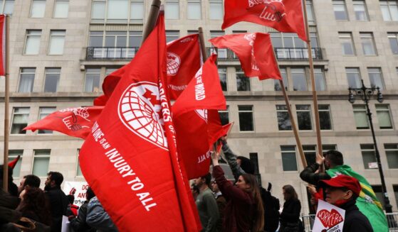 Members of the Democratic Socialists of America gather outside of a Trump-owned building on May Day on May 1, 2019, in New York City.