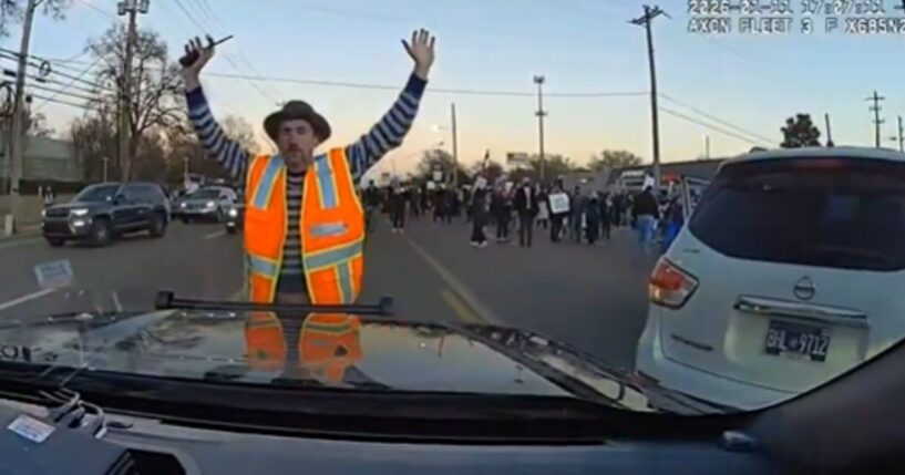 An anti-ICE protester stands in front of a police car in Memphis, Tennessee, on Jan. 11, 2026.
