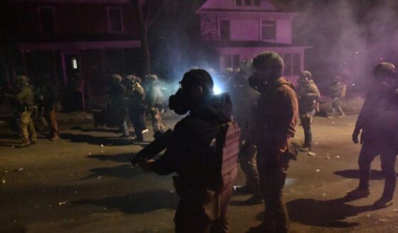Federal law enforcement agents and police officers in riot gear walk amid smoke from crowd control devices after protests broke out following the shooting of a Venezuelan man by a Immigration and Customs Enforcement agent in Minneapolis, Minnesota, on Jan. 14, 2026.