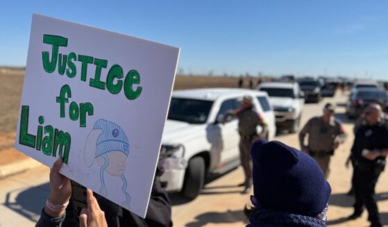 A protestor holds an anti-ICE signs during a demonstration and vigil outside the South Texas Family Residential Center in Dilley, Texas, on Jan. 28, 2026.