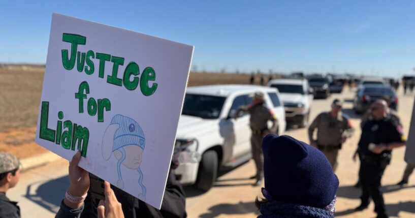 A protestor holds an anti-ICE signs during a demonstration and vigil outside the South Texas Family Residential Center in Dilley, Texas, on Jan. 28, 2026.