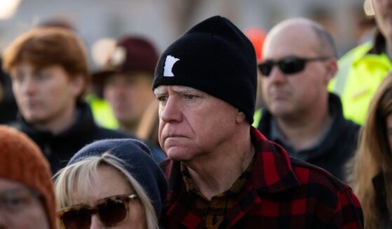 Minnesota Gov. Tim Walz and his wife Gwen Walz look on during a vigil for Renee Good on the steps of the state capitol building on Jan. 9, 2026, in St. Paul, Minnesota.