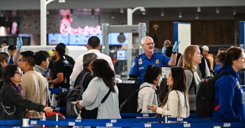 A TSA agent works at a security checkpoint as travelers wait in line at George Bush Intercontinental Airport in Houston, Texas, on Nov. 7, 2025.