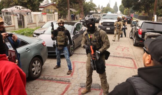 Border Patrol agents and other law enforcement clear the way for an authorized car to pass while investigating a shooting involving a federal agent on Wednesday morning in Willowbrook, California, on Jan. 21, 2026.