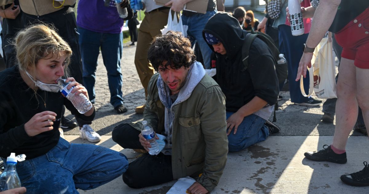 Demonstrators protesting outside a U.S Immigration and Customs Enforcement facility, including Democratic congressional candidate Kat Abughazaleh, left, react after being tear-gassed on Sept. 19, 2025, in Broadview, Illinois.