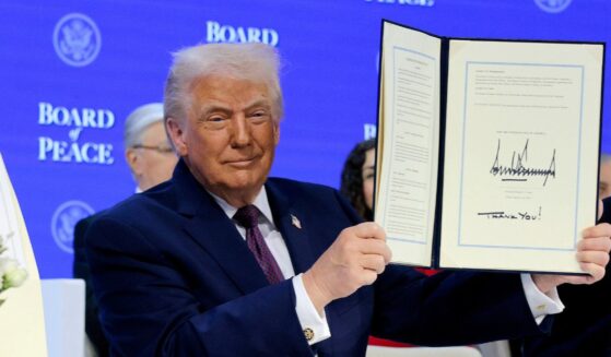 President Donald Trump holds up his signature on the founding charter during a signing ceremony for the “Board of Peace” at the World Economic Forum on Jan. 22, 2026, in Davos, Switzerland.
