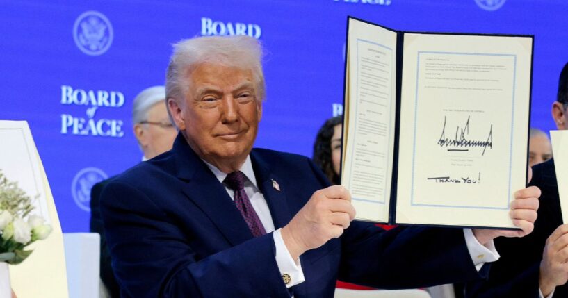 President Donald Trump holds up his signature on the founding charter during a signing ceremony for the “Board of Peace” at the World Economic Forum on Jan. 22, 2026, in Davos, Switzerland.