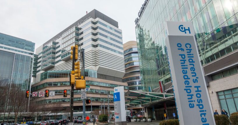 People walking on street in front of buildings of Hospital of the University of Pennsylvania and the Children's Hospital of Philadelphia.