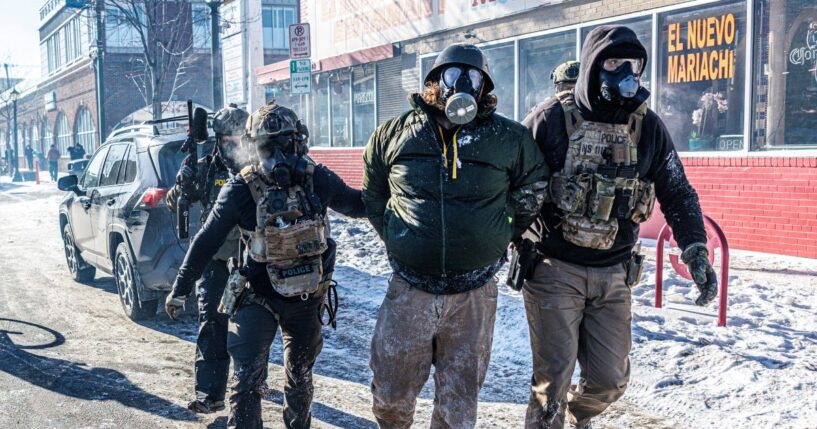 Federal agents detain a protester along a commercial street during clashes following the fatal shooting of a demonstrator earlier in the day, on Jan. 24, 2026, in Minneapolis, Minnesota.