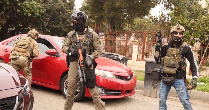 Border Patrol agents and other law enforcement ask a car to make room for a police vehicle to pass while investigating a shooting involving a federal agent on Wednesday morning in Willowbrook on Jan. 21, 2026.
