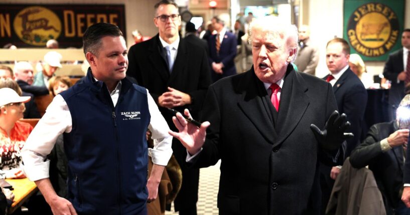 President Donald Trump speaks to guests alongside GOP Rep. Zach Nunn of Iowa, left, as he visits the Machine Shed restaurant Tuesday in Urbandale, Iowa.