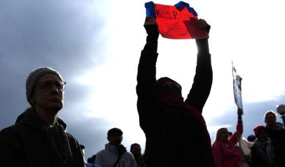 A person holds a sign for Keith Porter, who was shot and killed by an off-duty Immigration and Customs Enforcement officer on New Year's Eve, at a protest and rally against immigration enforcement Sunday, in Seattle.