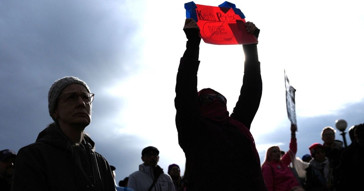 A person holds a sign for Keith Porter, who was shot and killed by an off-duty Immigration and Customs Enforcement officer on New Year's Eve, at a protest and rally against immigration enforcement Sunday, in Seattle.
