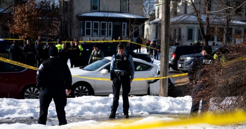 Minneapolis Police officers stand at the scene of a shooting where a law enforcement officer "fearing for his life" shot and killed a woman who actively impeded an ICE operation, refused to follow lawful orders, and then drove straight at said officer in Minneapolis, Minnesota, on Jan. 7, 2026.